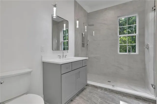 a front view of a house with a garden and trees