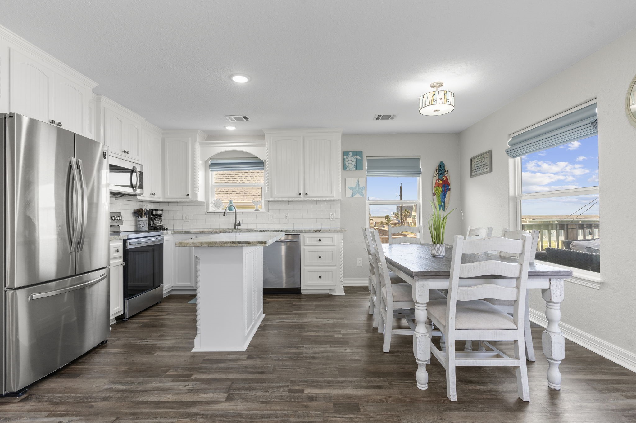 203 Sandpebble Place Surfside Beach, TX 77541 - Photo 12 of 27 a kitchen with a table chairs refrigerator and cabinets