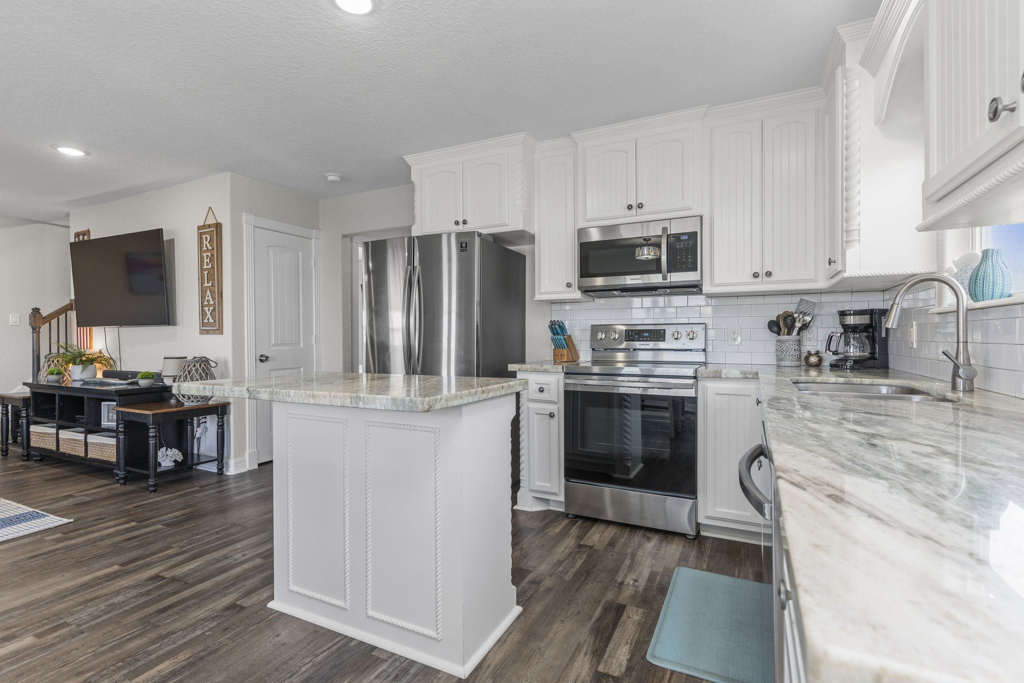 203 Sandpebble Place Surfside Beach, TX 77541 - Photo 13 of 27 a kitchen with kitchen island granite countertop stainless steel appliances and wooden cabinets