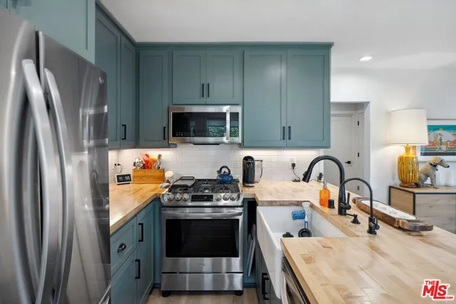a kitchen with stainless steel appliances granite countertop a refrigerator stove and sink