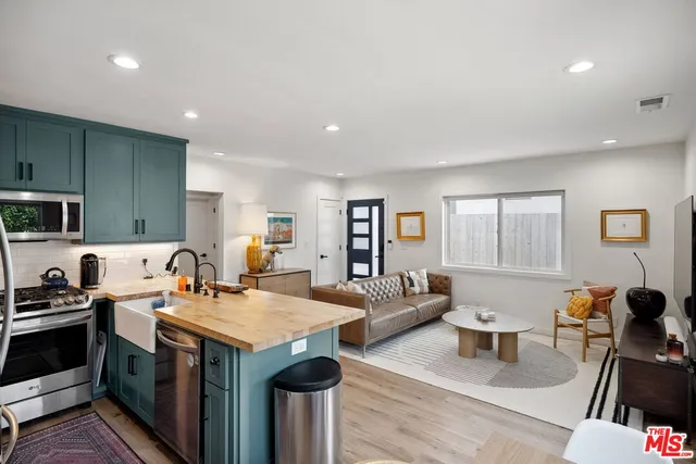 a open kitchen with stainless steel appliances granite countertop a stove and a refrigerator