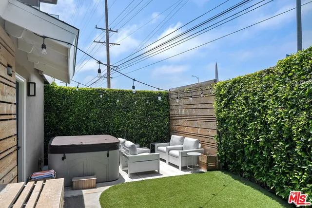 a view of a patio with chairs and potted plants
