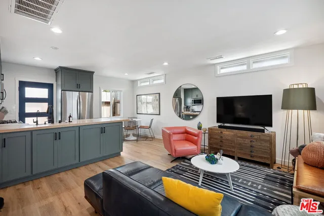 a living room with furniture a flat screen tv and a large window