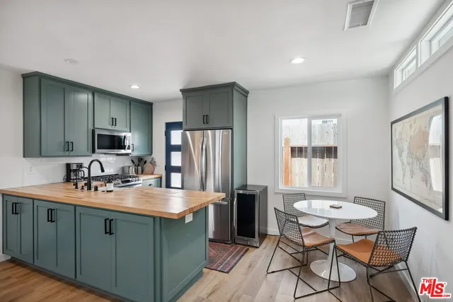 a kitchen with stainless steel appliances granite countertop a refrigerator and a sink