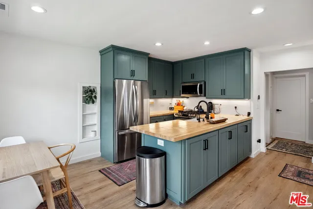 a kitchen with kitchen island a sink stove and refrigerator