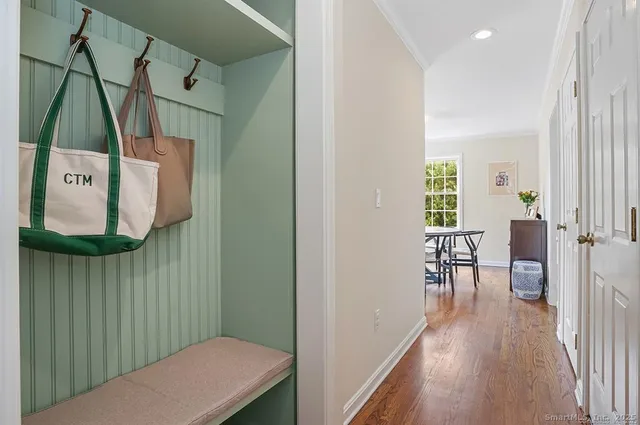 a view of a hallway with wooden floor and furniture