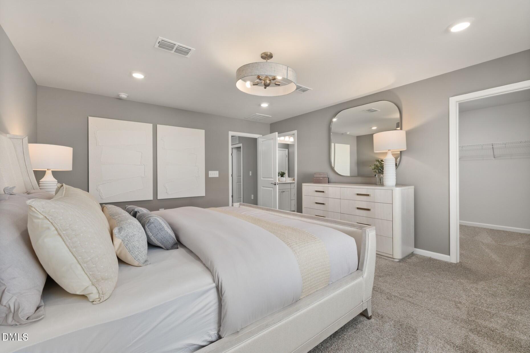 2913 Denson Road Fuquay-Varina, NC 27526 - Photo 11 of 30 a spacious bedroom with a bed and a chandelier