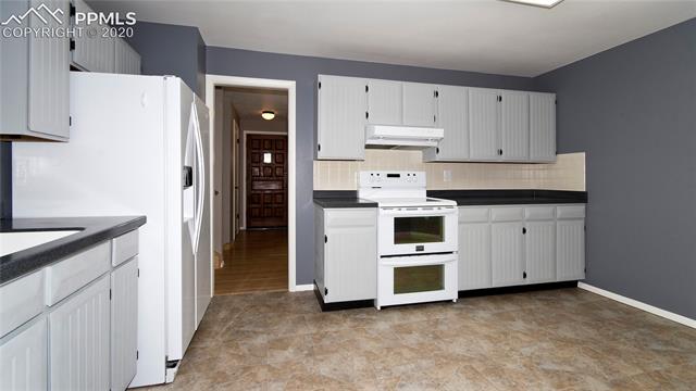 4027 Maxwell Road Colorado Springs, CO 80909 - Photo 12 of 35 Kitchen with lots of counter space, looks through to foyer and living room.