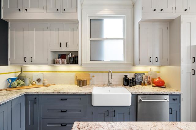 a kitchen with a sink a cabinets and wooden floor