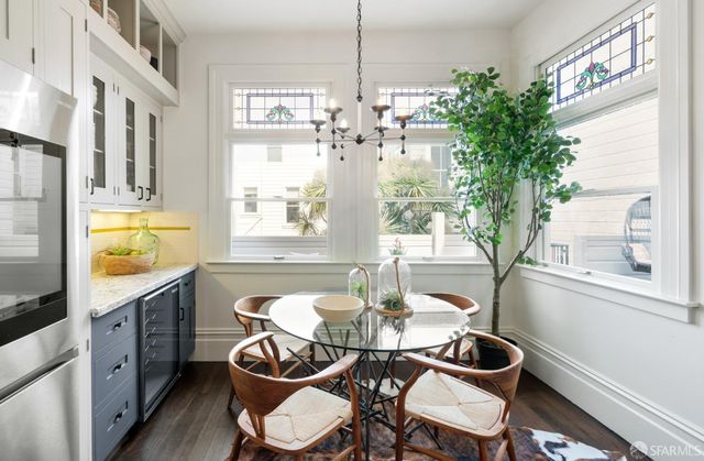 a dining room with furniture a chandelier and wooden floor