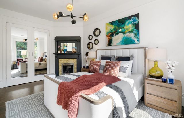 a bedroom with a bed a ceiling fan and a fireplace