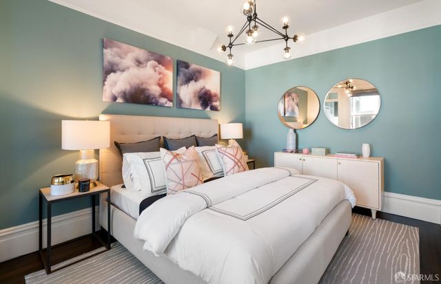 a bedroom with bed and a chandelier