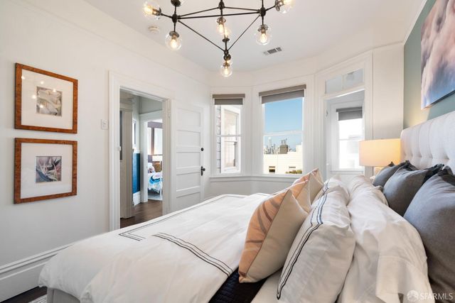 a bedroom with a large bed and a chandelier