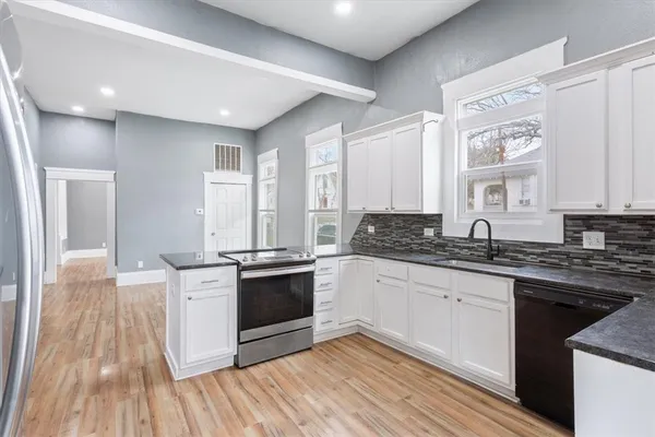 a kitchen with stainless steel appliances granite countertop a stove a sink and a refrigerator