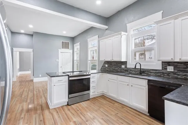 a kitchen with stainless steel appliances granite countertop a stove a sink and a refrigerator