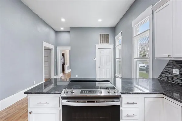 a kitchen with granite countertop a stove and a sink