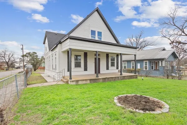 a view of a house with a yard and sitting area