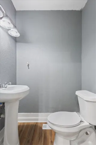 a bathroom with a toilet a sink and a mirror