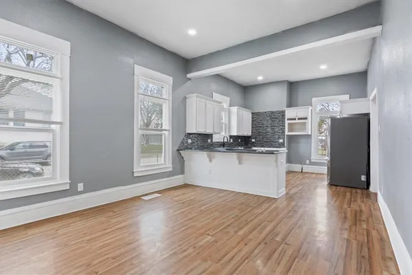 a kitchen with stainless steel appliances granite countertop a refrigerator a stove and a wooden floors