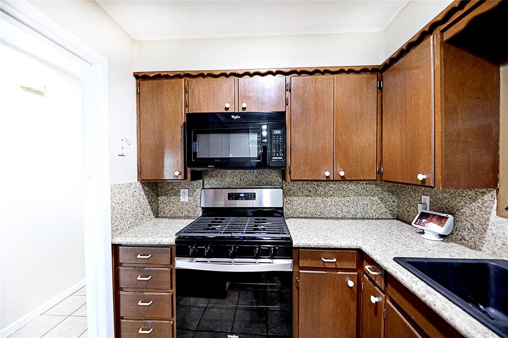 702 Decatur Street Bowie, TX 76230 - Photo 15 of 36 a kitchen with a stove and a sink