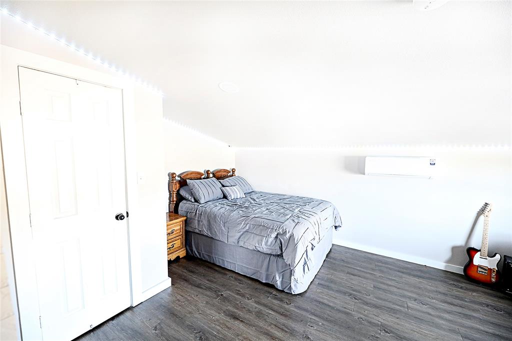 702 Decatur Street Bowie, TX 76230 - Photo 17 of 36 a bedroom with a bed and wooden floor