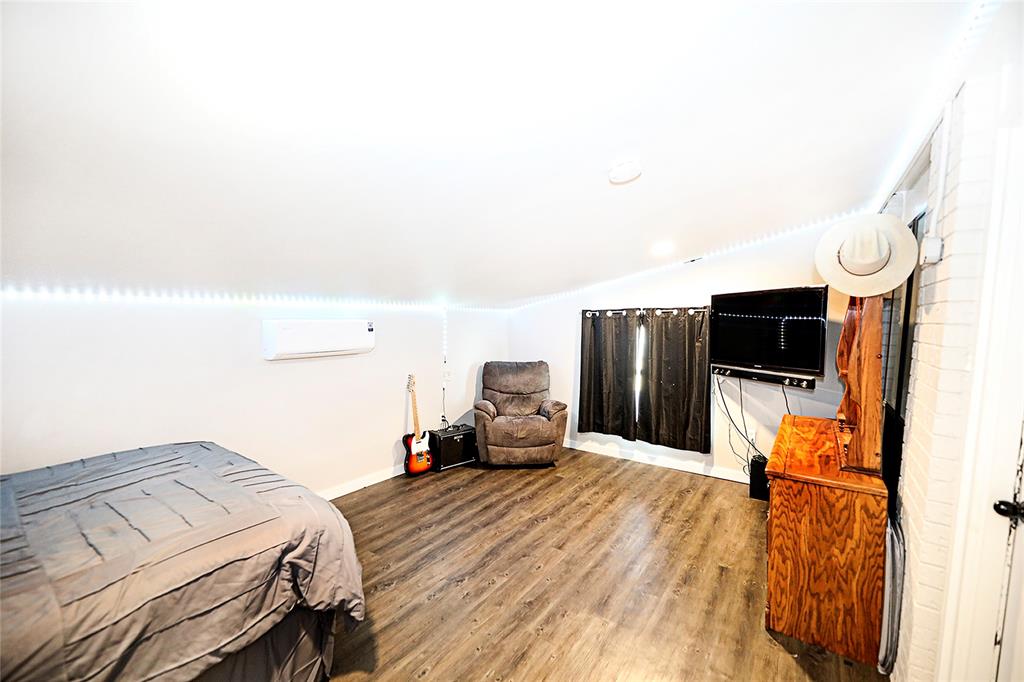 702 Decatur Street Bowie, TX 76230 - Photo 18 of 36 a bedroom with a bed and a flat screen tv