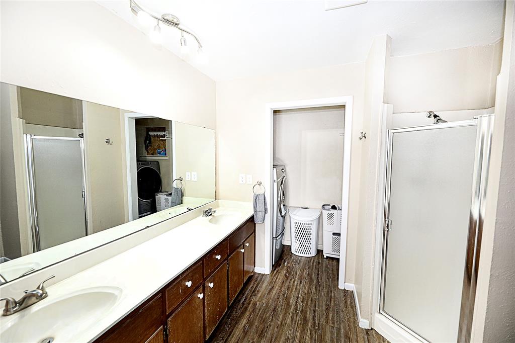 702 Decatur Street Bowie, TX 76230 - Photo 27 of 36 a spacious bathroom with a double vanity sink a mirror and a shower
