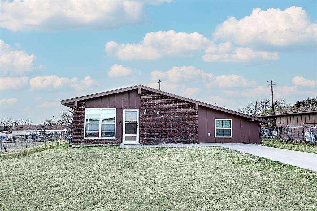 702 Decatur Street Bowie, TX 76230 - Photo 4 of 36 a front view of a house with a garden