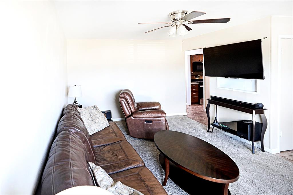 702 Decatur Street Bowie, TX 76230 - Photo 9 of 36 a living room with furniture and a flat screen tv