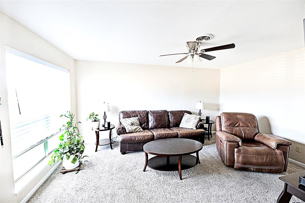 702 Decatur Street Bowie, TX 76230 - Photo 10 of 36 a living room with furniture a rug and a large window