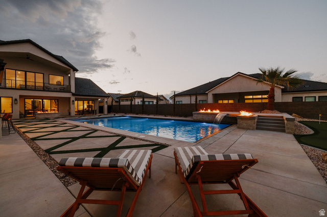 2281 South Crimson Cliffs Way St. George, UT 84790 - Photo 46 of 47 Pool at dusk featuring a patio, a fenced backyard, and a balcony