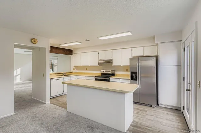 a kitchen with stainless steel appliances a refrigerator sink and microwave