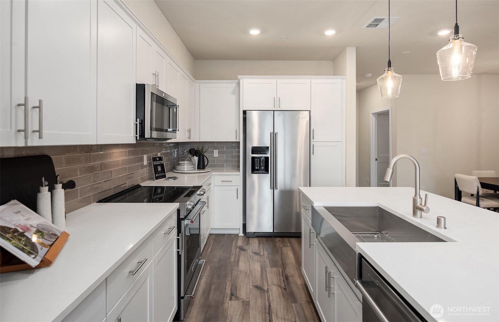 6901 Northeast 184th Lane, Unit 403 Kenmore, WA 98028 - Photo 3 of 19 a kitchen that has a sink a center island stainless steel appliances and cabinets