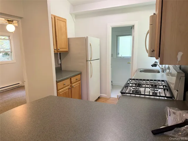 a kitchen with granite countertop a refrigerator stove and sink