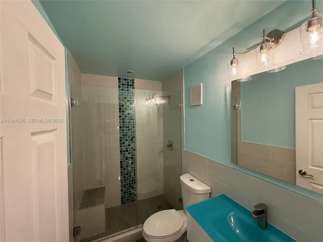 a bathroom with a toilet a sink and shower
