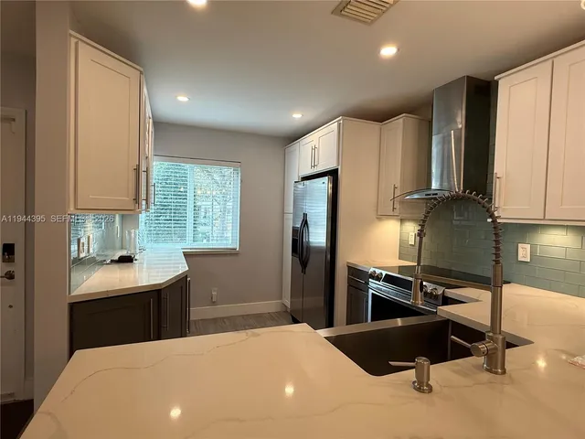 a kitchen with stainless steel appliances a refrigerator and a sink