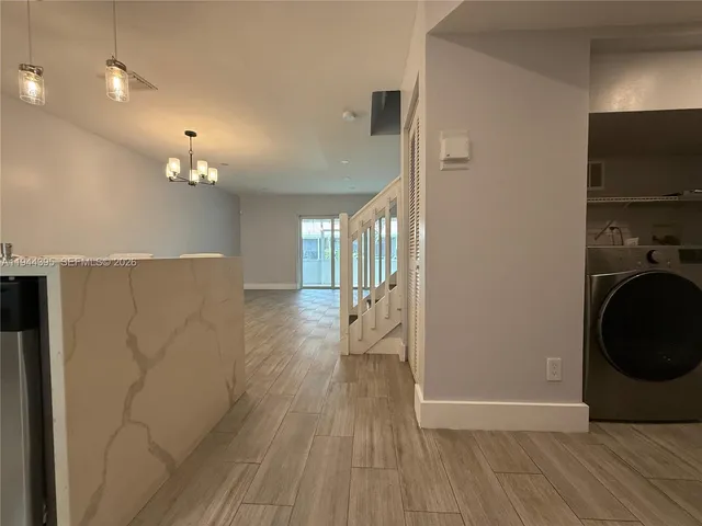 a view of a hallway with wooden floor and cabinets