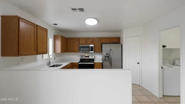 a kitchen with granite countertop a refrigerator sink and cabinets