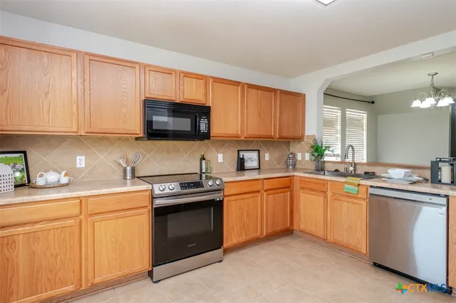 a kitchen with granite countertop white cabinets sink and stainless steel appliances