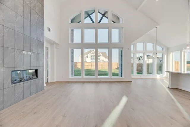 a view of an empty room with a fireplace and a window