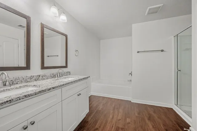 a bathroom with a granite countertop sink toilet a large mirror a vanity and shower