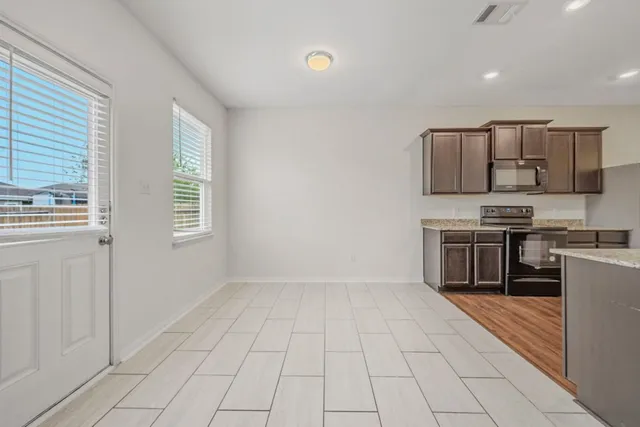 a kitchen with stainless steel appliances a refrigerator and a stove top oven