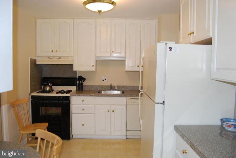 17317 Fletchall Road Poolesville, MD 20837 - Photo 4 of 18 a kitchen with granite countertop a sink a stove and refrigerator