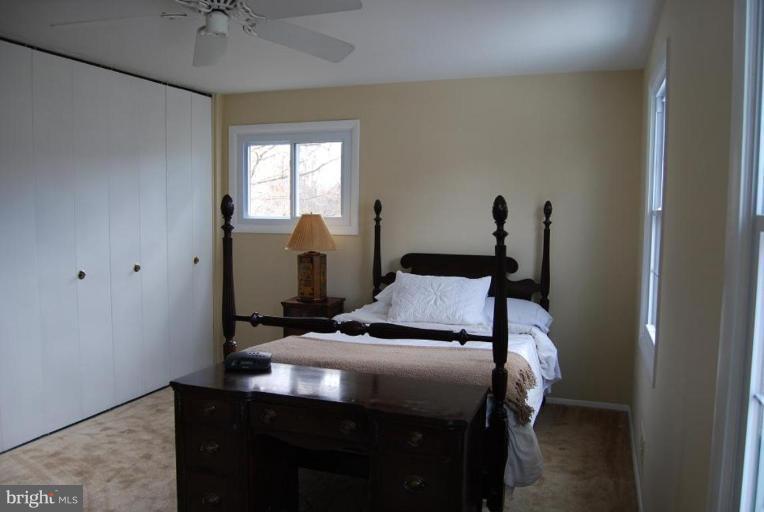 17317 Fletchall Road Poolesville, MD 20837 - Photo 8 of 18 a bedroom with a bed and large windows