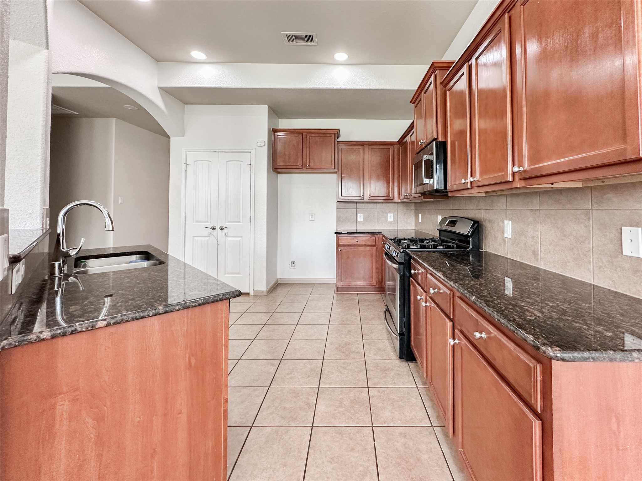 20319 Little Wing Drive Spring, TX 77388 - Photo 24 of 49 a kitchen with stainless steel appliances granite countertop a sink stove and cabinets