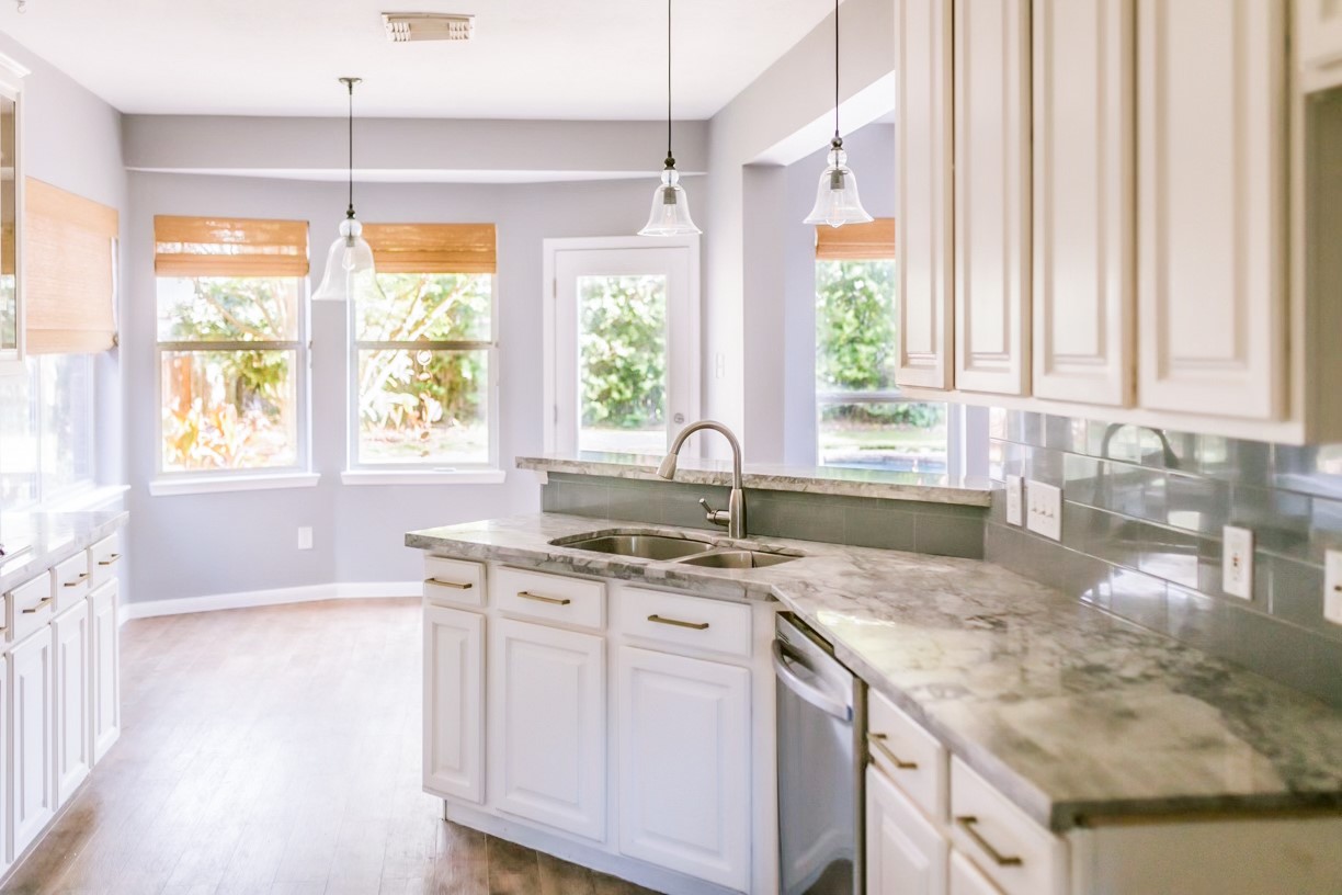 22402 Rue Canyon Court Katy, TX 77450 - Photo 4 of 18 This bright kitchen features pristine white cabinetry accented by modern hardware, a deep undermount double-basin stainless steel sink, and a high-arc gooseneck faucet.