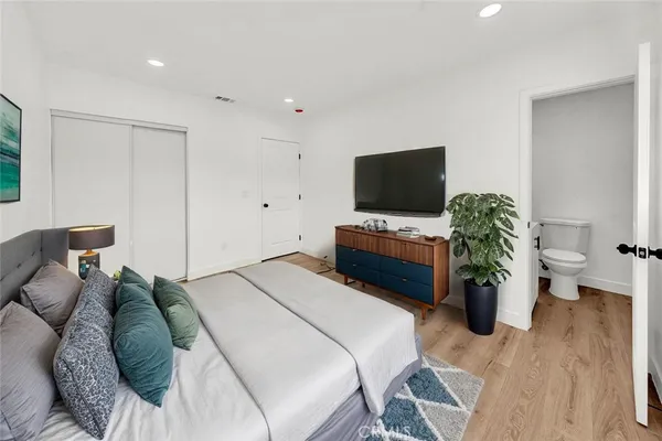 a bedroom with a bed and a potted plant