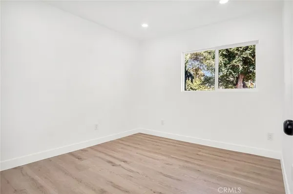 a view of a hallway with wooden floor and a window