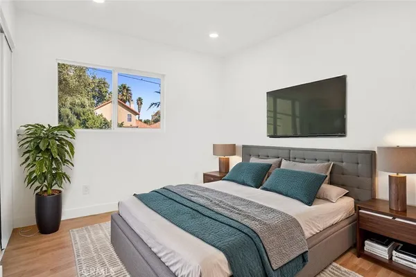 a bedroom with a bed and a potted plant