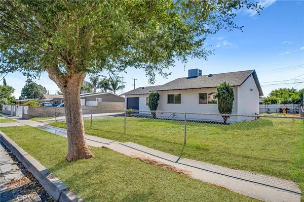 a view of a house with backyard and a tree